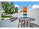 Patio area with outdoor bar-height table, lounge chairs, and lawn at 10664 Starkey Rd, Seminole, FL 33777