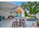 Patio area with outdoor bar-height table, lounge chairs, and lawn at 10664 Starkey Rd, Seminole, FL 33777