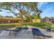 Backyard showing patio, lounge chairs, play equipment and mature trees at 10664 Starkey Rd, Seminole, FL 33777