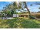 Spacious backyard with mature trees, play equipment, and storage shed at 10664 Starkey Rd, Seminole, FL 33777