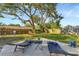 Backyard showing patio, lounge chairs, play equipment and mature trees at 10664 Starkey Rd, Seminole, FL 33777