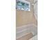 Tiled bathtub area featuring a window providing natural light and a neutral color palette for a calming experience at 10664 Starkey Rd, Seminole, FL 33777