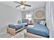 Charming bedroom featuring two twin beds, a ceiling fan, and soothing blue and white bedding at 10664 Starkey Rd, Seminole, FL 33777