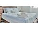 Close up view of a modern bedroom with blue accents and stacked white towels on a blue and white bedspread at 10664 Starkey Rd, Seminole, FL 33777