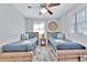 Inviting bedroom featuring two twin beds with sleek wood frames and a stylish round wall decoration at 10664 Starkey Rd, Seminole, FL 33777