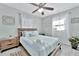 This light-filled bedroom features a modern ceiling fan and wood furnishings, providing comfort and style at 10664 Starkey Rd, Seminole, FL 33777