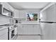 Well-lit kitchen featuring white cabinets, stainless steel appliances, and an outside view at 10664 Starkey Rd, Seminole, FL 33777
