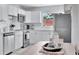 Bright kitchen featuring white cabinets, stainless steel appliances, and a view to the outside at 10664 Starkey Rd, Seminole, FL 33777