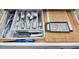 Neatly organized kitchen drawer featuring cutlery, knives, and cutting boards, optimizing space and functionality at 10664 Starkey Rd, Seminole, FL 33777