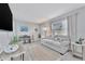 Bright living room featuring a comfortable sofa, wood floors, modern decor, and adjacent dining area at 10664 Starkey Rd, Seminole, FL 33777