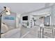 Bright, open-concept living room with modern furniture, stainless steel appliances, and light-colored wood floors at 10664 Starkey Rd, Seminole, FL 33777