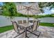 A paver patio features a seating area with umbrella and grill at 10664 Starkey Rd, Seminole, FL 33777