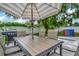 A table with seating under a striped umbrella and a grill on the brick patio at 10664 Starkey Rd, Seminole, FL 33777