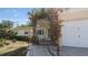 Charming single-story home's entrance with a flowering pergola, landscaping, and walkway at 10912 N 61St St, Temple Terrace, FL 33617