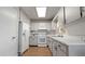 Well-lit kitchen featuring white appliances, white cabinets, and brown tile flooring at 10912 N 61St St, Temple Terrace, FL 33617