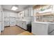 Bright kitchen with white cabinets, countertops, appliances, tile backsplash and hardwood-style floors at 10912 N 61St St, Temple Terrace, FL 33617