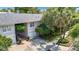 A two-story townhome with an attached garage, paved driveway, and mature trees and landscaping at 1211 W Horatio St # A, Tampa, FL 33606