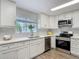 Bright kitchen features white cabinets, stainless steel appliances, and wood-look flooring at 1211 W Horatio St # A, Tampa, FL 33606