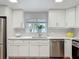 Bright kitchen features white cabinets, stainless steel appliances, and wood-look flooring at 1211 W Horatio St # A, Tampa, FL 33606