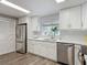 Bright kitchen features white cabinets, stainless steel appliances, and wood-look flooring at 1211 W Horatio St # A, Tampa, FL 33606