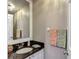 Elegant powder room with a black countertop, decorative mirror, and stylish fixtures, adds a touch of luxury at 1211 W Horatio St # A, Tampa, FL 33606