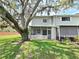 Backyard with lush green lawn, shaded by a large tree, adjacent to the house at 12701 N 57Th St, Tampa, FL 33617