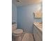Cozy half bathroom with light blue walls, a toilet, and a sink with vanity at 12701 N 57Th St, Tampa, FL 33617