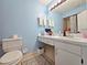 Bathroom featuring vanity with drawers, toilet and soft blue walls at 12701 N 57Th St, Tampa, FL 33617