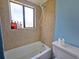 Neutral bathroom with a bathtub, showerhead, and a window for natural light at 12701 N 57Th St, Tampa, FL 33617