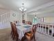 Well-lit dining room with a modern chandelier, carpet, and access to the staircase at 12701 N 57Th St, Tampa, FL 33617