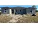 New construction duplex with a grey exterior, new roof, and partially landscaped yard at 13009 Ridgely Cir, Port Charlotte, FL 33981