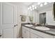 Bright bathroom featuring granite countertops, double sinks, white cabinets, and modern fixtures at 13118 Rain Lily Dr, Riverview, FL 33579