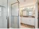 Bright bathroom boasts dual sinks, a glass-enclosed shower, and a large framed mirror at 13118 Rain Lily Dr, Riverview, FL 33579