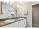 Bright bathroom boasts dual sinks with granite countertops, a framed mirror, and plenty of storage at 13118 Rain Lily Dr, Riverview, FL 33579