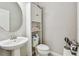 Cozy half bathroom featuring a pedestal sink, toilet, and built-in storage at 13118 Rain Lily Dr, Riverview, FL 33579