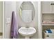 Half bathroom with pedestal sink, oval mirror, and stacked storage at 13118 Rain Lily Dr, Riverview, FL 33579