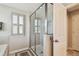 Bathroom featuring a glass-enclosed shower, grey tile, and a window with plantation shutters at 13118 Rain Lily Dr, Riverview, FL 33579