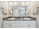 Bright bathroom boasts dual sinks with granite countertops, a framed mirror, and plenty of storage at 13118 Rain Lily Dr, Riverview, FL 33579