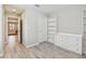 Bright bedroom featuring stylish wood flooring, white trim, and ample natural light from the open doorway at 13118 Rain Lily Dr, Riverview, FL 33579