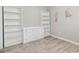 Bedroom featuring wood-look floors, neutral walls, and white dressers with open bookcases at 13118 Rain Lily Dr, Riverview, FL 33579