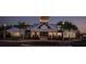 Exterior view of neighborhood clubhouse at dusk, featuring manicured landscaping, sidewalks and ample parking at 13118 Rain Lily Dr, Riverview, FL 33579