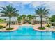 Gorgeous community pool area framed by palm trees, cabanas, and comfortable seating for relaxing gatherings at 13118 Rain Lily Dr, Riverview, FL 33579