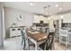 Open dining area with view of kitchen and stainless appliances, granite counters, and seating for six at 13118 Rain Lily Dr, Riverview, FL 33579