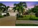 Charming two-story home featuring a two-car garage, manicured lawn and lush tropical landscaping at 13118 Rain Lily Dr, Riverview, FL 33579
