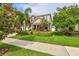 Beautiful two-story home with a well-manicured lawn and colorful tropical landscaping at 13118 Rain Lily Dr, Riverview, FL 33579