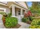 Charming front porch with stone support columns and colorful landscaping at 13118 Rain Lily Dr, Riverview, FL 33579