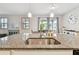 Bright kitchen featuring granite counters, a stainless sink, pendant lighting and an open view to the dining area at 13118 Rain Lily Dr, Riverview, FL 33579