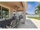 Covered patio with ceiling fan, dining area, hot tub, and view of the backyard's mature landscaping at 13118 Rain Lily Dr, Riverview, FL 33579