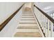 Close-up of a clean and modern stairway with light wood treads and white risers and banisters at 13118 Rain Lily Dr, Riverview, FL 33579
