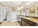 Bright bathroom with a double sink vanity with granite counters and decorative art at 15135 Azra Dr, Odessa, FL 33556